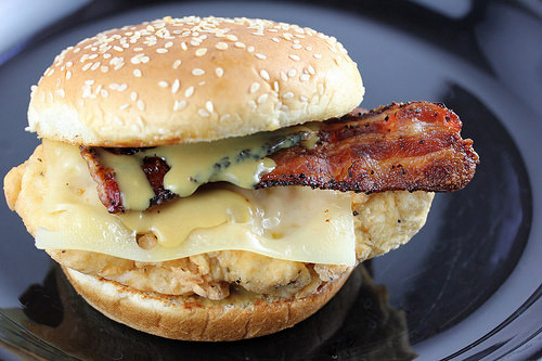 Crispy chicken bacon swiss sandwich on sesame bun with curly fries