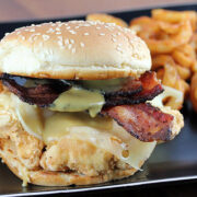 Crispy chicken bacon swiss sandwich on sesame bun with curly fries