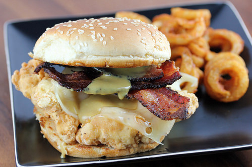 Crispy chicken bacon swiss sandwich on sesame bun with curly fries
