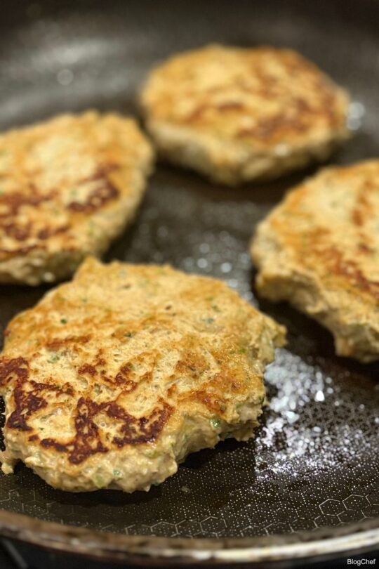 Chicken burgers frying in a pan
