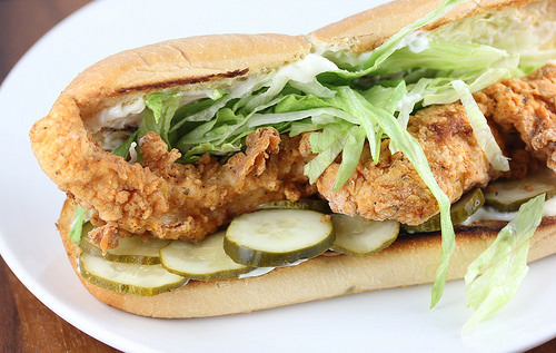 Popeyes-style shrimp po’ boy loaded with fried shrimp, pickles, and lettuce on bread