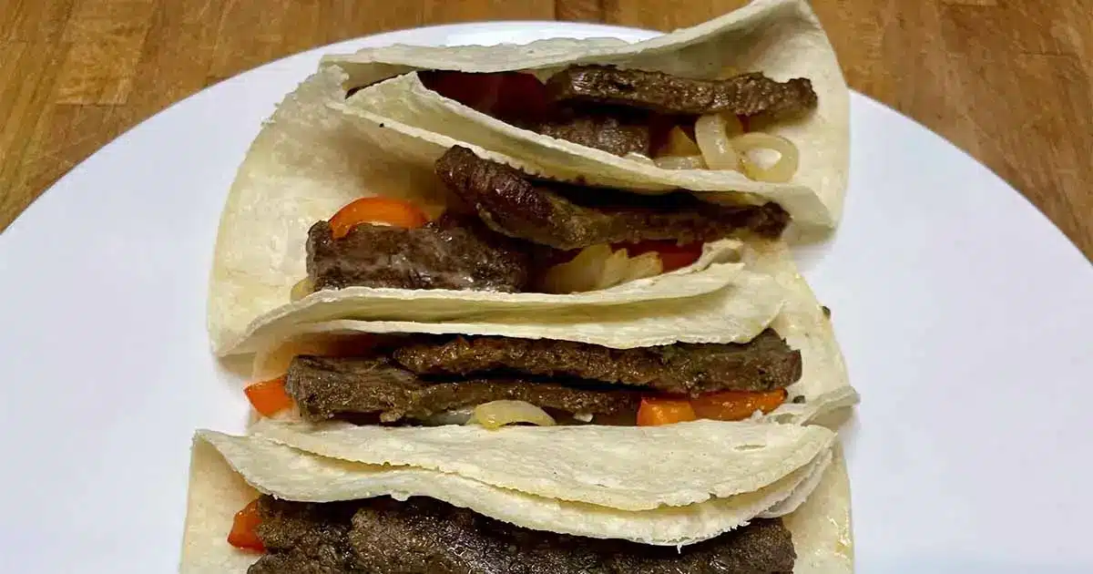 Carne asada prepared and stuffed into soft corn tortillas.