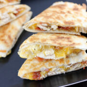 Chicken bacon ranch quesadilla slices on a black plate