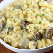 Bowl of steak mac and cheese topped with parsley