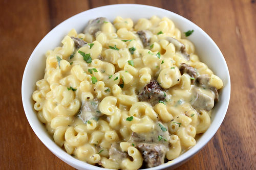 Bowl of steak mac and cheese topped with parsley