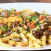 Taco fries topped with ground beef cheese and diced tomatoes