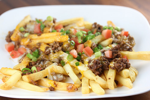 Taco fries topped with ground beef cheese and diced tomatoes