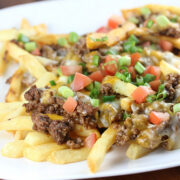Taco fries topped with ground beef cheese and diced tomatoes