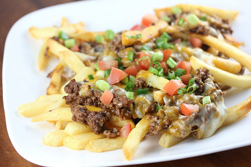 Taco fries topped with ground beef cheese and diced tomatoes