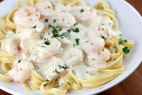 Plate of Olive Garden shrimp alfredo pasta topped with creamy sauce