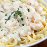 Plate of Olive Garden shrimp alfredo pasta topped with creamy sauce