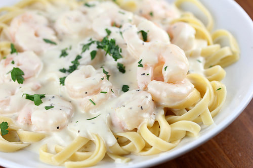 Plate of Olive Garden shrimp alfredo pasta topped with creamy sauce