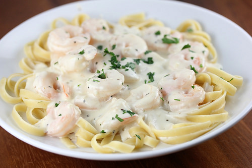 Plate of Olive Garden shrimp alfredo pasta topped with creamy sauce