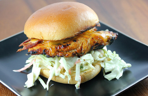 Grilled chicken sandwich with melted cheddar and creamy coleslaw on a bun