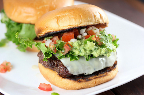 Pico guacamole burger with lettuce tomato and melted cheese on a toasted bun