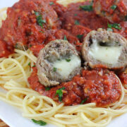 Plate of spaghetti topped with marinara sauce and asiago stuffed meatballs