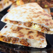 Chorizo and egg quesadillas sliced and served on a black plate