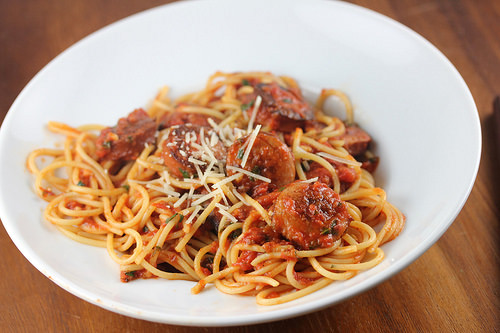 Spaghetti topped with smoked sausage marinara sauce and grated cheese