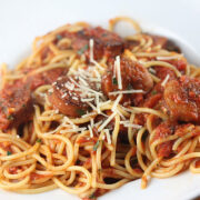 Spaghetti topped with smoked sausage marinara sauce and grated cheese