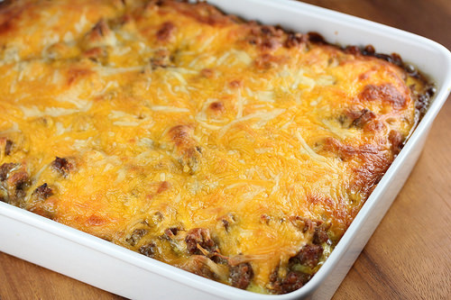 Cheesy sausage and hash brown casserole baked in a white dish
