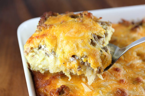 Cheesy sausage and hash brown casserole baked in a white dish