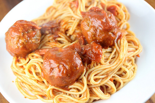Plate of spaghetti with meatballs covered in marinara sauce