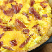Close-up of tater tot breakfast pizza showing crispy bacon and melted cheddar over eggs