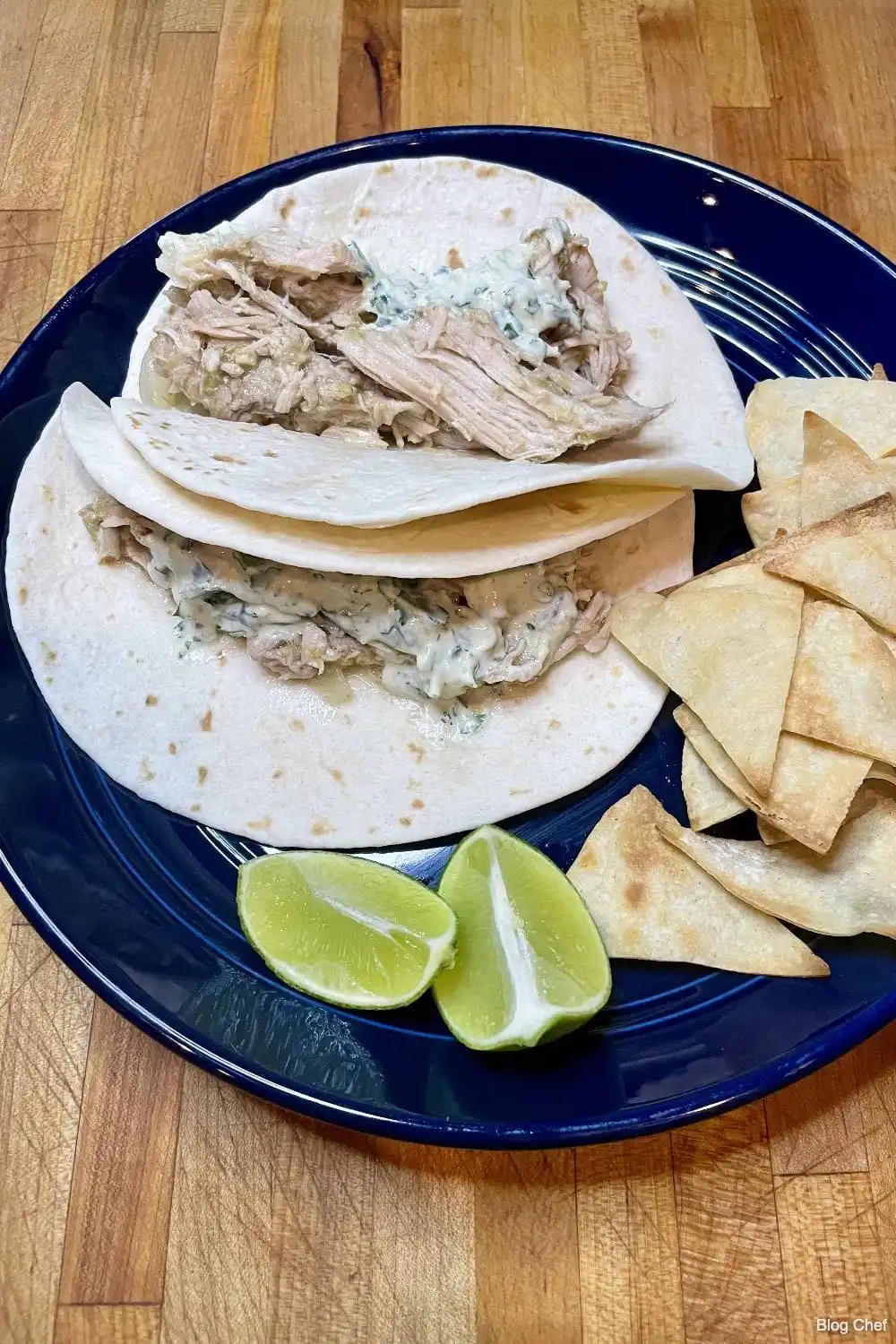 Top view of pork verde tacos on blue plate.