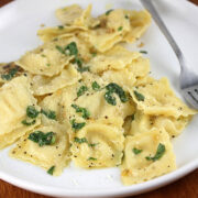 Ravioli with garlic basil oil on a plate with a fork