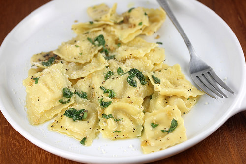 Ravioli with garlic basil oil on a plate with a fork