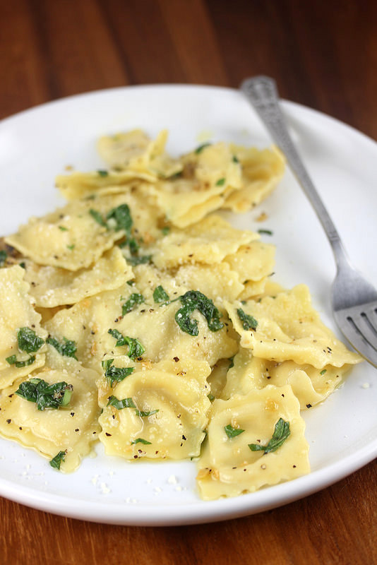 Ravioli with garlic basil oil on a plate with a fork