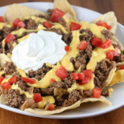 Nachos Bell Grande topped with ground beef cheese tomatoes and sour cream