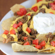 Nachos Bell Grande topped with ground beef cheese tomatoes and sour cream