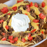 Nachos Bell Grande topped with ground beef cheese tomatoes and sour cream