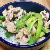 Prepared pork and pepper stir fry over white rice.