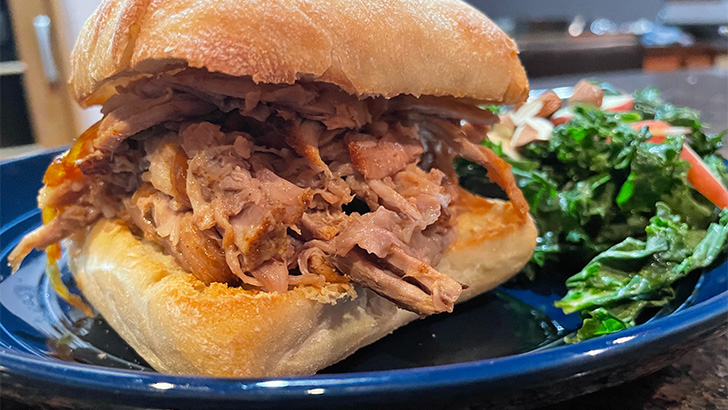 Close up view of oven-roasted pulled pork served on ciabatta roll.