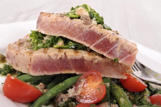 Oven-baked tuna steaks served over green beans and tomatoes