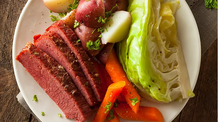 Close up view of slow cooker corned beef on serving dish.