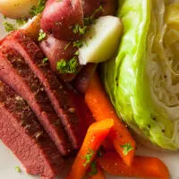 Close up view of slow cooker corned beef on serving plate.