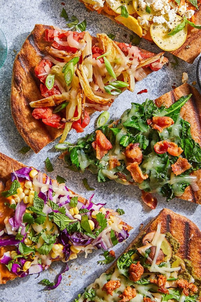 Overhead view of different types of grilled pizza.