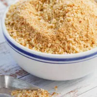 Bowl of bread crumbs on table.