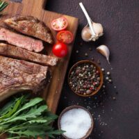 Seared and oven roasted prime rib steak on serving platter.