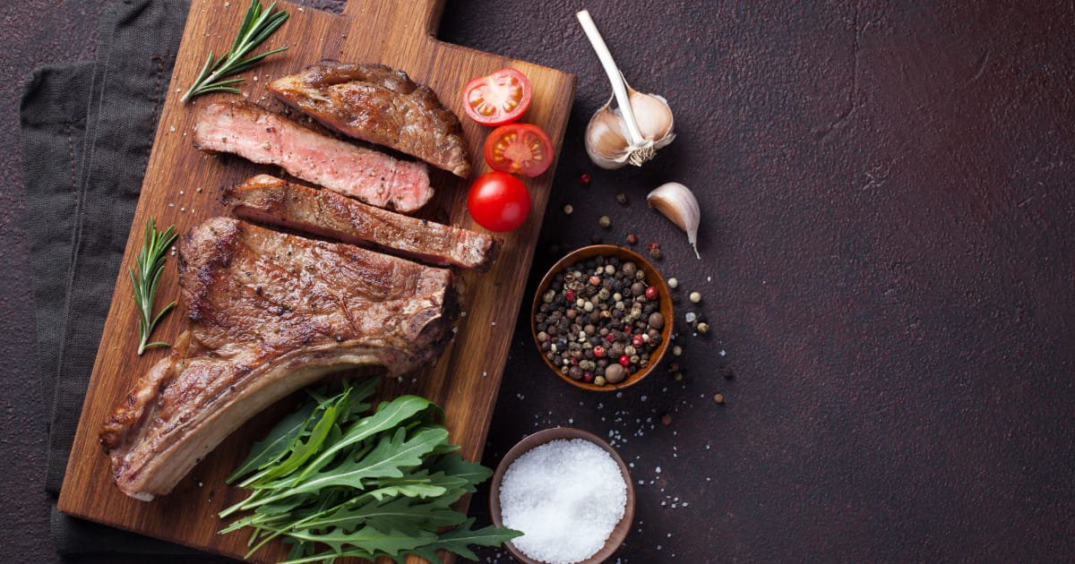 Seared and oven roasted prime rib steak on serving platter.