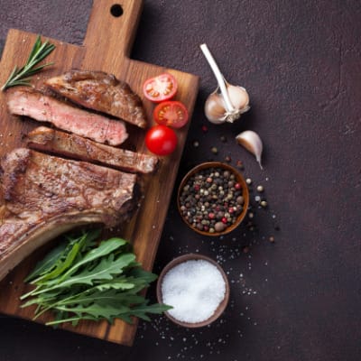 Seared and oven roasted prime rib steak on serving platter.