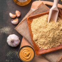 Top view of dry mustard in flat wooden bowl.