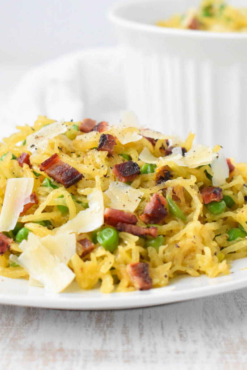 Side view of prepared spaghetti squash carbonara on plate.