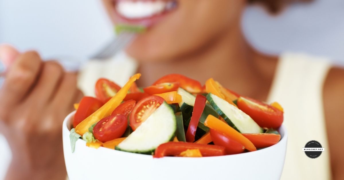 Woman eating bowl of raw, healthy foods