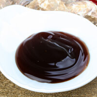 Close up view of oyster sauce in white bowl.