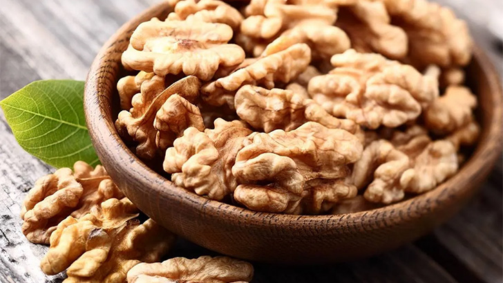 Walnut halves in a bowl on table. 