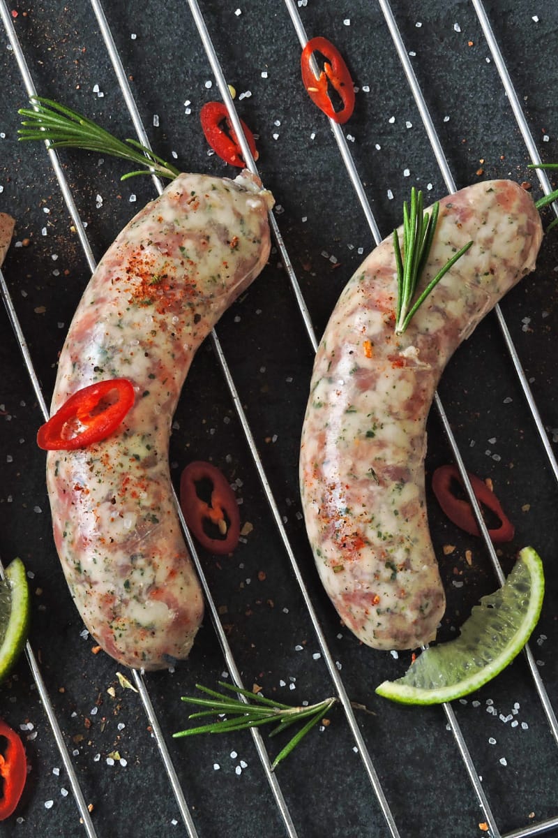 Four Italian sausages cooking on the grill. 